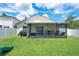 Well-maintained backyard featuring a screened-in patio, a grill, and green grass at 1531 Tiverton Blvd, Winter Garden, FL 34787