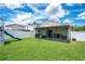 Backyard with a screened-in patio, green lawn, playground and white vinyl fence at 1531 Tiverton Blvd, Winter Garden, FL 34787