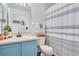 Bathroom with blue vanity, striped shower curtain, decorative mirror and sink at 1531 Tiverton Blvd, Winter Garden, FL 34787