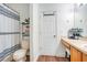 Bright bathroom featuring a striped shower curtain, chrome storage shelf, and wood-look flooring at 1531 Tiverton Blvd, Winter Garden, FL 34787