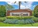Stone Creek community entrance sign featuring lush landscaping and vibrant flowers at 1531 Tiverton Blvd, Winter Garden, FL 34787