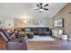 Spacious living room with wood floors, leather furniture, a ceiling fan, and a TV at 1531 Tiverton Blvd, Winter Garden, FL 34787