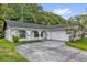 Charming single-story home featuring an arched portico and a spacious driveway leading to an attached garage at 1533 Ravana Dr, Orlando, FL 32822