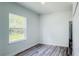 Bedroom featuring wood-look flooring, closet and a window overlooking a green space at 15625 Sw 37Th Cir, Ocala, FL 34473