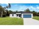 Charming single-story home features a well-manicured lawn and a blue two-car garage at 15625 Sw 37Th Cir, Ocala, FL 34473