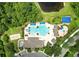 Aerial view of community pool area with pool, seating, cabanas, playground, and beach volleyball court, surrounded by lush greenery at 1640 Wild Indigo Ter, Oviedo, FL 32766