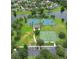 Aerial view of community tennis and basketball courts near a lake, surrounded by manicured lawns and trees at 1640 Wild Indigo Ter, Oviedo, FL 32766