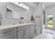Bright bathroom with modern vanity and glass-enclosed shower; backyard view at 1640 Wild Indigo Ter, Oviedo, FL 32766