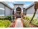 Beautiful arched double door entry with stone accents and lush landscaping leading to the home at 1640 Wild Indigo Ter, Oviedo, FL 32766