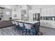 Modern kitchen with seating at the large island, stainless appliances, and gray color palette at 1640 Wild Indigo Ter, Oviedo, FL 32766