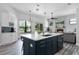 Open kitchen with island, stone-clad fireplace, stainless steel appliances, and backyard view at 1640 Wild Indigo Ter, Oviedo, FL 32766
