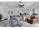 Spacious living room features a plush sectional sofa, ceiling fan, and open layout to the kitchen at 1640 Wild Indigo Ter, Oviedo, FL 32766