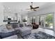 Bright living room featuring an open layout with ceiling fan, stylish furniture, and backyard access at 1640 Wild Indigo Ter, Oviedo, FL 32766