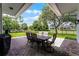 A covered patio is set for outdoor dining overlooking the manicured lawn at 1640 Wild Indigo Ter, Oviedo, FL 32766