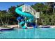Fun spiral water slide into community pool surrounded by palm trees, providing a recreational amenity at 1640 Wild Indigo Ter, Oviedo, FL 32766