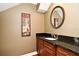 Powder room showcasing a dark vanity with granite countertop and decorative mirror at 1649 Lake Baldwin Ln, Orlando, FL 32814