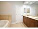 Bathroom featuring a double sink vanity and a tiled jacuzzi tub at 1649 Lake Baldwin Ln, Orlando, FL 32814