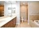 This warm bathroom has a double vanity, tub and glass enclosed shower at 1649 Lake Baldwin Ln, Orlando, FL 32814
