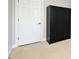 Bedroom with tan carpet, a door, and a black wardrobe at 1649 Lake Baldwin Ln, Orlando, FL 32814