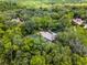 An aerial view showcases a home with a screened-in pool, encircled by a dense forest for ultimate seclusion and privacy at 1717 Fountainhead Dr, Lake Mary, FL 32746