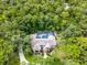 An aerial view of the property with a large screened-in pool surrounded by lush, mature trees and landscaping at 1717 Fountainhead Dr, Lake Mary, FL 32746