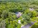 Aerial view of a brick home with a screened pool surrounded by a lush green landscape in a quiet neighborhood at 1717 Fountainhead Dr, Lake Mary, FL 32746