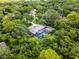 An aerial view of a stunning property with a screened-in pool area surrounded by a vibrant canopy of green trees at 1717 Fountainhead Dr, Lake Mary, FL 32746