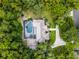 An aerial view shows a house with a large pool in the backyard and surrounded by lush trees, offering privacy at 1717 Fountainhead Dr, Lake Mary, FL 32746