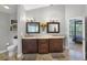 This primary bathroom features a double sink with updated fixtures, a wood floor, and a view to the main bedroom at 1717 Fountainhead Dr, Lake Mary, FL 32746