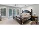 This primary bedroom features a large bed with access to the backyard through double doors and adjacent nightstands at 1717 Fountainhead Dr, Lake Mary, FL 32746