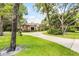 Expansive lawn and driveway leading up to a beautiful brick home surrounded by mature trees at 1717 Fountainhead Dr, Lake Mary, FL 32746