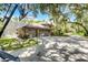A three car garage and covered lanai are connected to this home with mature trees at 1717 Fountainhead Dr, Lake Mary, FL 32746