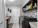 Well-organized laundry room with front loading washer, patterned accent wall, workspace, and ample shelving at 1717 Fountainhead Dr, Lake Mary, FL 32746