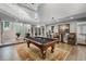 Spacious living room featuring a billiard table, bar, and staircase to the second floor at 1717 Fountainhead Dr, Lake Mary, FL 32746