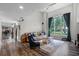 Comfortable living room featuring wood floors, a leather sofa, bright windows, and stylish decor at 1717 Fountainhead Dr, Lake Mary, FL 32746
