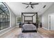 Spacious main bedroom with a four-poster bed, large arched window, and neutral decor at 1717 Fountainhead Dr, Lake Mary, FL 32746