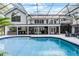 A screened-in pool and deck with an outdoor bar and dining area offer the perfect space for entertaining at 1717 Fountainhead Dr, Lake Mary, FL 32746