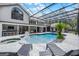 A screened-in pool with a hot tub and poolside bar for entertaining, all within a lush outdoor setting at 1717 Fountainhead Dr, Lake Mary, FL 32746
