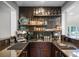 Stylish wet bar featuring dark granite countertops, mosaic tile backsplash, and open shelving at 1717 Fountainhead Dr, Lake Mary, FL 32746