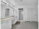 A spacious, tiled bathroom offers double sinks, generous counter space, enclosed glass shower, and bright, white cabinets at 1731 Knotting Hill Dr, Orlando, FL 32835