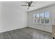 Neutral bedroom with wood-look floors, a ceiling fan, and a window with plantation shutters at 1731 Knotting Hill Dr, Orlando, FL 32835