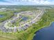 Panoramic aerial view of the community showcases a tranquil lake surrounded by homes and verdant landscapes at 17860 Passionflower Cir, Clermont, FL 34714