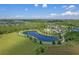Beautiful aerial view featuring a community with a lake, pool and clubhouse, manicured lawns, and mature landscaping at 17860 Passionflower Cir, Clermont, FL 34714