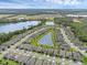 Scenic aerial view highlights a community nestled alongside a large lake, surrounded by lush greenery and well-maintained homes at 17860 Passionflower Cir, Clermont, FL 34714