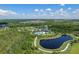 An aerial view of a community with a scenic pond, walking path, and green spaces at 17860 Passionflower Cir, Clermont, FL 34714