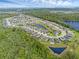 Aerial view of a community showcasing residential homes, ponds, natural scenery, and landscaping at 17860 Passionflower Cir, Clermont, FL 34714