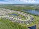 Aerial view of a community with residential homes surrounding a lake, bordered by nature, and lush landscaping at 17860 Passionflower Cir, Clermont, FL 34714