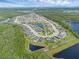 Aerial view of the community features homes encircling a central lake, complemented by natural green surroundings and landscaping at 17860 Passionflower Cir, Clermont, FL 34714