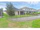 Backyard featuring a screened lanai, black metal fence, retaining wall, and lush green lawn with manicured landscaping at 17860 Passionflower Cir, Clermont, FL 34714