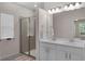 The bathroom features double sinks, a large mirror, and a walk-in shower with glass door at 17860 Passionflower Cir, Clermont, FL 34714